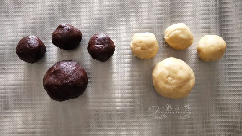 小熊爪印饼干--小盆友都喜欢,分割两色面团。
先把面团平均分成两份，再将其中一份平均分成三份。