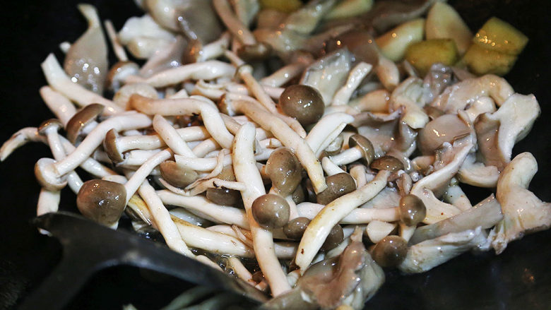双菇炒肉片,将预先处理好的平菇和真姬菇倒入锅内翻炒几下