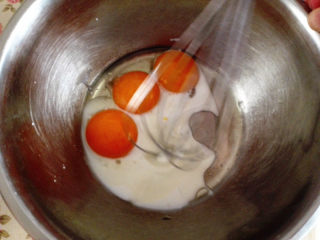 小熊蛋糕,蛋黄盆里加入牛奶和玉米油用手动打蛋器打散，