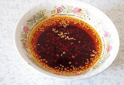 重庆小面 ,将热油浇在辣椒碗中，搅拌均匀即成油辣子