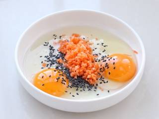 爆浆吐司,准备一个口径较大的浅盘子磕入鸡蛋，再加入切碎的胡萝卜和黑芝麻，也可以放葱花或火腿丁。