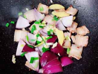 土豆回锅肉,放入花椒粒爆香，放入葱姜蒜、洋葱爆香。