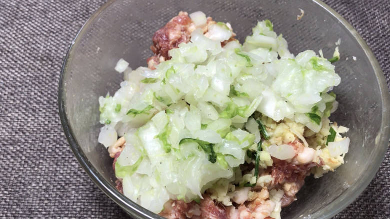 白菜卷肉,将腌制好的菜梗挤干水分，放入肉末中，拌匀