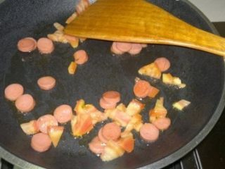 火腿煎蛋卷,平底锅放入适量油（最好是橄榄油，健康），放入火腿和西红柿翻炒片刻