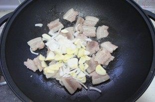 香菇小炒肉,肉片用自身的油脂煸至变色后，倒入葱蒜片炒香