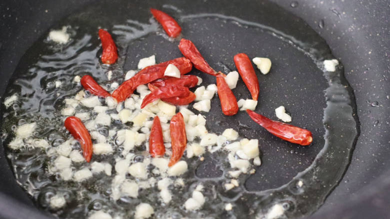 香肠炒西葫芦,起油锅爆香大蒜末，放入小红干辣椒炒香。