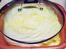 韩国泡菜,抹了粗粒海盐的白菜放入盆内，重物盖住腌一夜