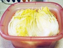 韩国泡菜,腌出水份的白菜用手挤出水份，要尽量挤干净，然后用清水冲洗掉粗粒海盐，把白菜放入矿泉水或凉白开中浸泡投洗