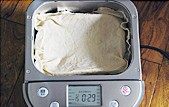 肉松火腿玉米沙拉吐司,将面团取出整圆，面包桶的搅拌棒拿掉，放入整圆的面团，面包桶表面盖上一块湿布，选择发酵模式，发酵1小时