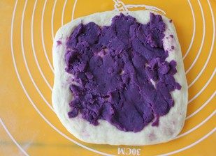 紫薯南瓜土司,在擀一张面皮，抹上紫薯泥