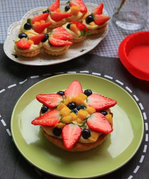 榛子奶油水果塔,脱模放凉后挤上卡仕达奶油，摆上草莓，蓝莓和芒果装饰，抹上镜面果胶。