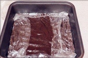 巧克力大理石土司,将其倒在事先垫有保鲜膜的硅胶垫上，表面覆盖一张保鲜膜，用刮板将其整成18*18CM的正方形。