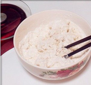 巧克力大理石土司,取一大碗先倒入水后依次放酵母、盐和面粉，用筷子搅成絮状。