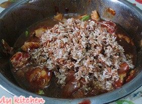 荷香红米鸡,倒入沥干水分的红米。搅拌均匀，让鸡块能够均匀的裹上红米。