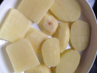 孜然烤土豆片,如图在盘底撒少量盐铺平，然后将土豆片未切花刀的一面摊方在上面