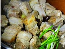 竹笋拷肉,倒入五花肉和排骨继续煸炒，把五花肉里的油脂逼出来，淋绍兴酒。