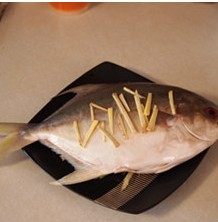 清蒸金鲳鱼,鲳鱼去除内脏洗净，在鱼身上划斜刀，再把姜丝塞一部份在鱼肚内，鱼背上放一些。