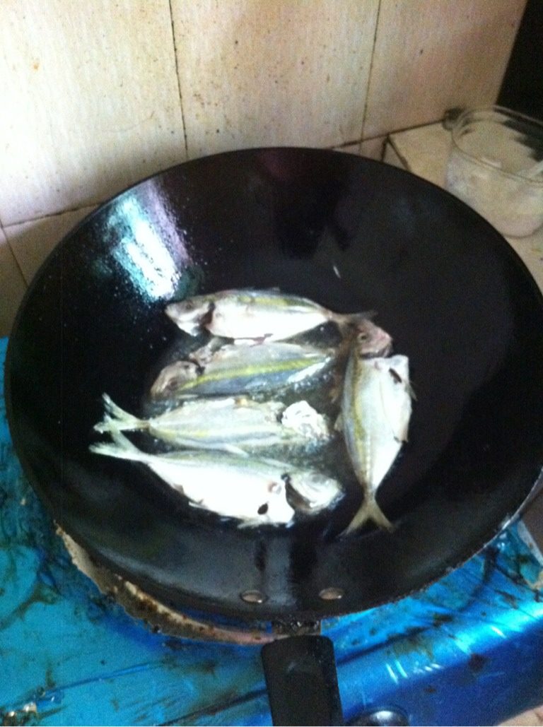 蒜汁金边鱼,如图锅内油热，下鱼用小火煎成两面金黄