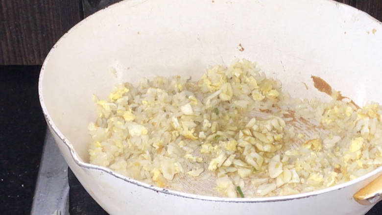 酸豇豆蛋炒饭,打开锅盖炒匀，加入蒜炒香，再一起炒匀