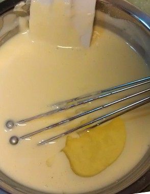咖啡芝士蛋糕,将大碗从热水中取出；待碗内食材温度降至30度左右时，依次加入蛋黄、蛋白和香草精