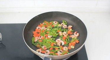 虾仁芝士焗饭,放虾仁和尖椒丝，调入1勺盐翻炒均匀至虾仁变色、熟透。