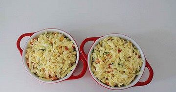 虾仁芝士焗饭,将炒好的米饭放进耐高温的烤碗中，在米饭表面撒上厚厚的马苏里拉奶酪丝。