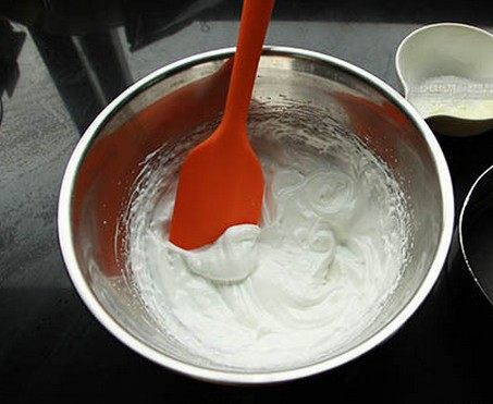 蛋白糖,奶粉和玉米淀粉过筛加入蛋白霜中，用硅胶刮刀翻拌加切拌均匀。