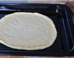 培根土豆披萨,将面皮直接放进烤箱的烤盘中，烤盘提前抹上一层橄榄油，并再次用手整理一下
