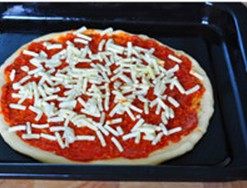 培根土豆披萨,在饼皮上均匀抹上意式茄汁酱，披萨酱上撒上1/3的马苏里拉芝士丝