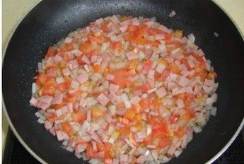 番茄火腿蛋饼 ,加入西红柿丁、火腿丁继续炒香