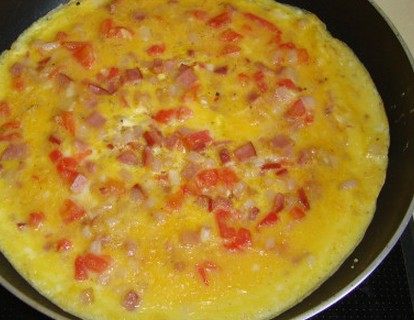 番茄火腿蛋饼 ,倒入蛋液，待蛋液即将凝固、金黄色即可