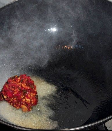 泡椒公鸡蛋,锅内下油六成油温时下入剁椒胡豆瓣酱并炒香