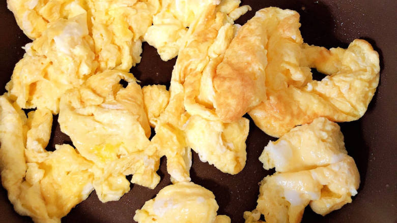 火腿青菜炒鸡蛋,锅中倒入油，加热至七成热，倒入鸡蛋炒熟。
