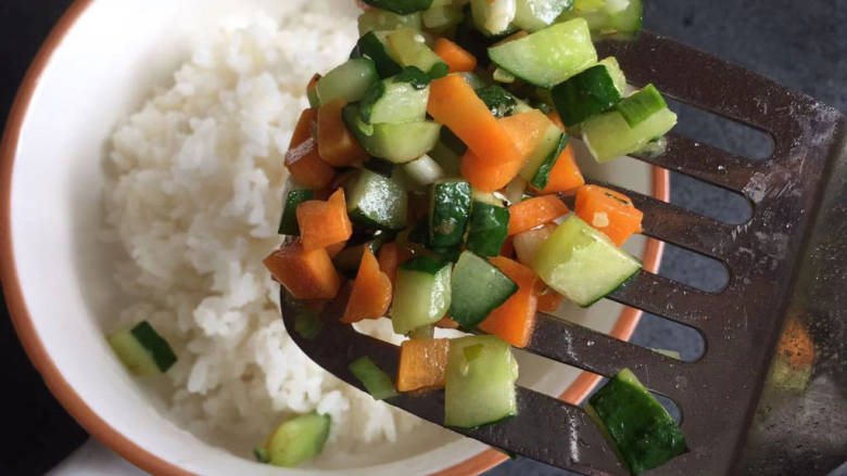 海苔拌饭,将炒好的黄瓜胡萝卜丁倒在米饭上（如果是剩米饭就热一下哦）