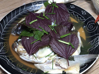 紫苏蒸鱼头,姜紫苏叶和葱段放在鱼头上面