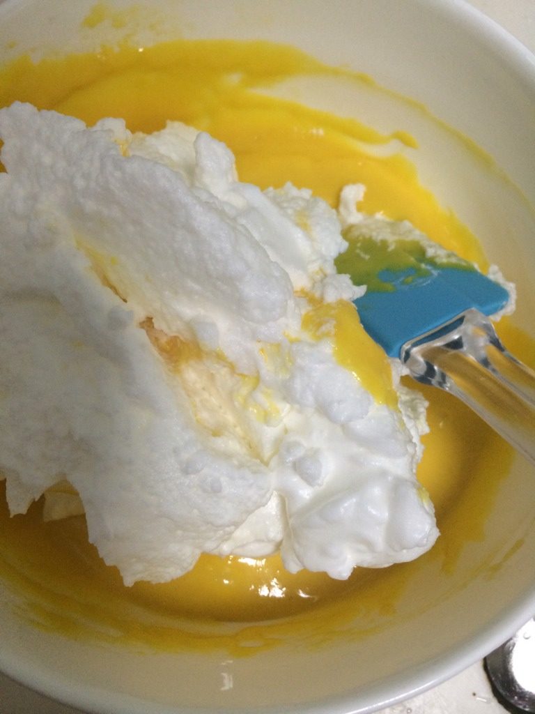葡萄干戚风蛋糕,如图将1/3蛋白倒入蛋黄面糊，用上下翻拌的手法拌匀；