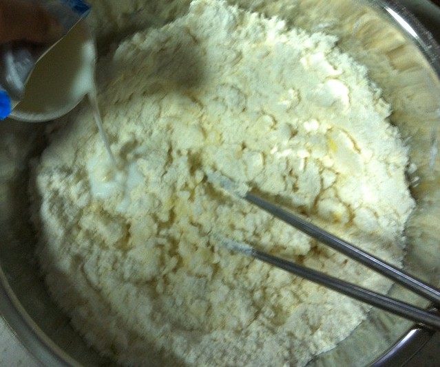 英式提子司康,分次倒入牛奶，可以用筷子慢慢搅拌面团