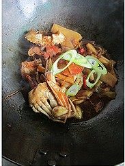 花蟹炒年糕,盖上木锅盖煮滚后，开盖收干汤汁，撒上大葱片即可盛出啦
