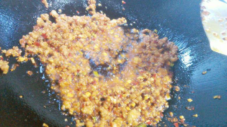 油淋茄子,锅里留少量油放肉末翻炒，加入葱姜蒜和豆瓣酱炒香。
