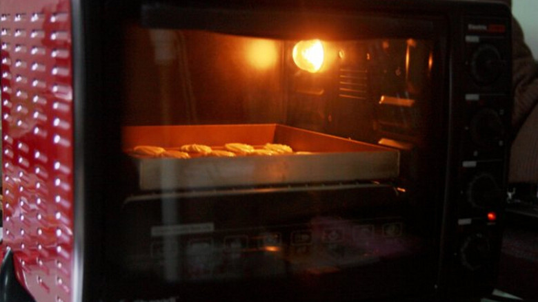 椰香曲奇饼干,放进180°C预热好的烤箱中层，烤12分钟