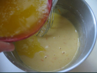 香橙玛德琳,将黄油倒入面糊，用打蛋器搅拌均匀