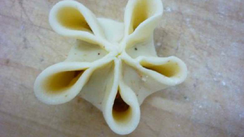 牧丹蒸饺,均分五点向中心捏在一起，形成如图所示的形状。