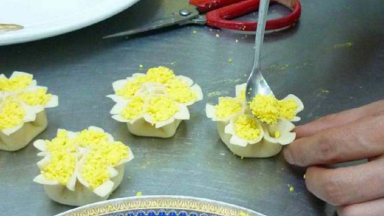 牧丹蒸饺,把熟的蛋黄碾碎，放入花瓣中作点缀。