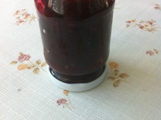 樱桃果酱,如图趁热装入消毒过的玻璃瓶中，倒扣，完全冷却后，放入冰箱冷藏。