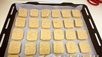 黄油花生饼干,预热烤箱175度，将饼干条取出后切片，烤盘上垫上油纸，饼干排列好，入烤箱，175度，约15分钟