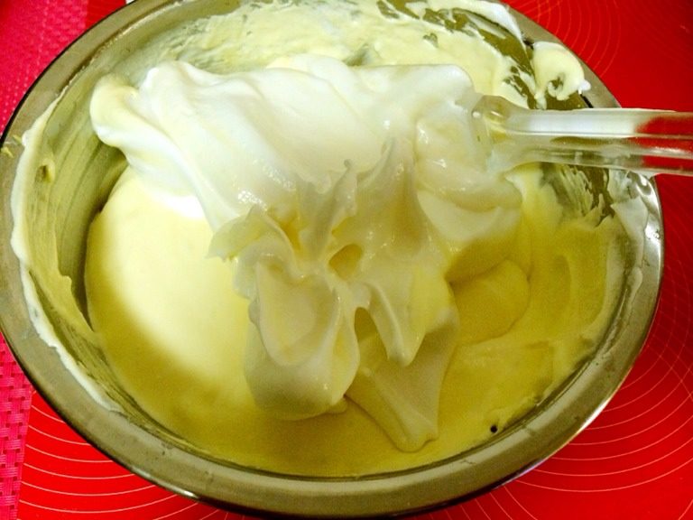大理石纹芝士蛋糕,把蛋白泡沫分次加入奶酪糊，用橡皮刮刀从底部往上快速翻拌均匀。

