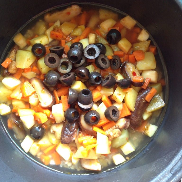 菌菇土豆焖燕麦饭,倒进电饭锅里，铺在米上面，再倒入黑橄榄。按煮饭键，跳闸后焖15分钟即可。