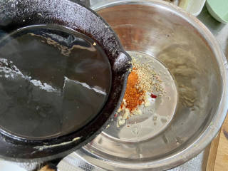 凉拌蒜蓉西兰花,取一耐热的盆，加入一汤匙辣椒粉，一汤匙熟白芝麻，蒜末小米辣，油烧到8成热，分次浇在辣椒粉上，激发香味，拌匀