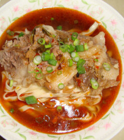 台湾牛肉面,手擀面煮好盛出，放上切好的牛肉片，浇上汤，撒香葱