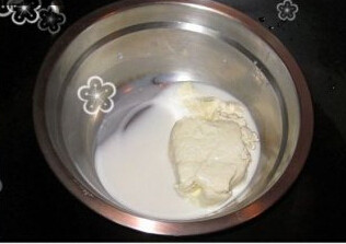 椰香轻乳酪蛋糕,乳酪加入牛奶放入锅内隔水加热